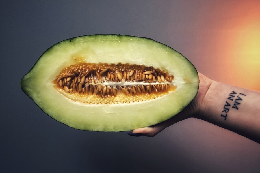 la moitié d'un melon à la main